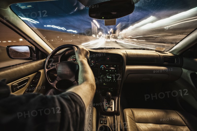 Interior of car driving through city streets at dusk