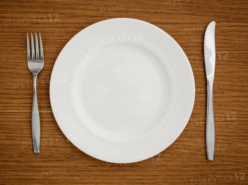 Studio shot of white plate with fork and knife