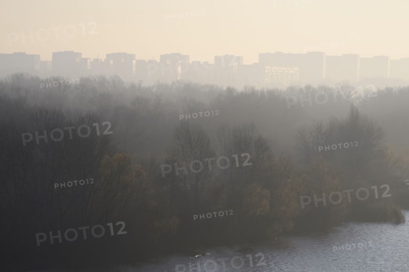 Ukraine, Dnepropetrovsk, Forest and remote city skyline at foggy dawn