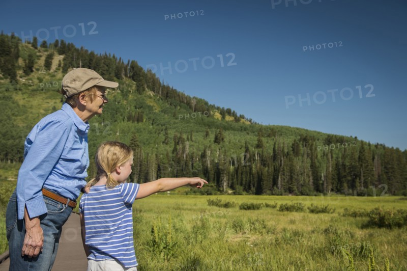 USA, Utah, Lake City, Girl (4-5) with grandmother standing on boardwalk by wetland