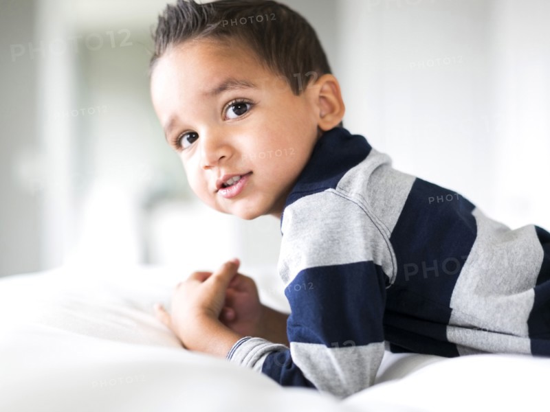Portrait of boy (2-3) lying on bed