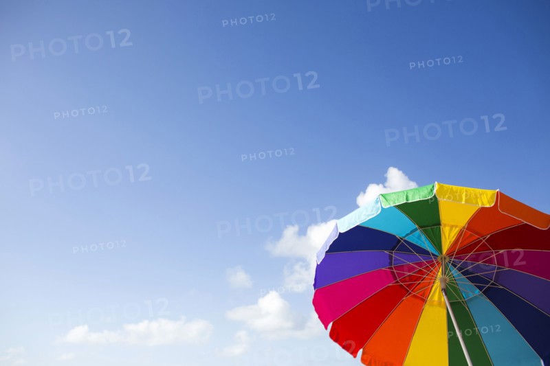 Low angle view of colorful beach umbrella against sky
