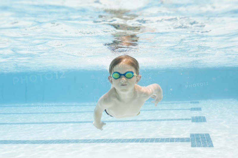 Boy (6-7) swimming in pool