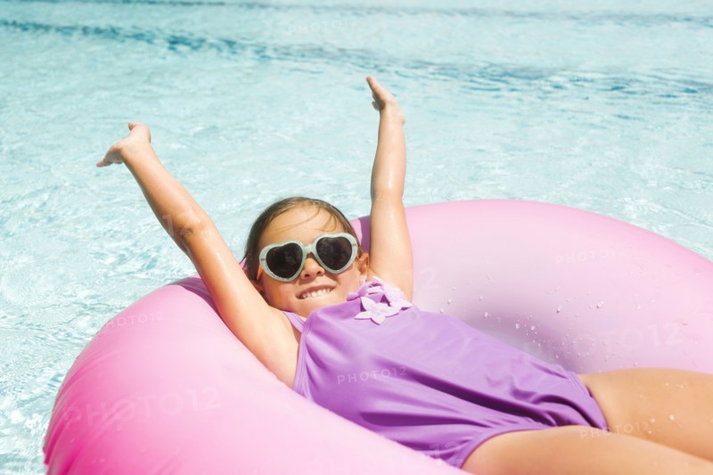 Smiling girl (4-5) relaxing in inflatable ring