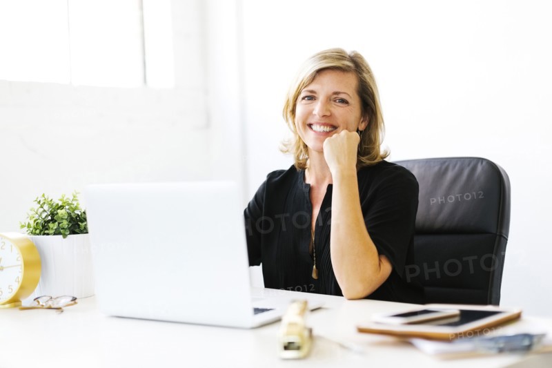 Portrait of Mature woman in office with hand on chin