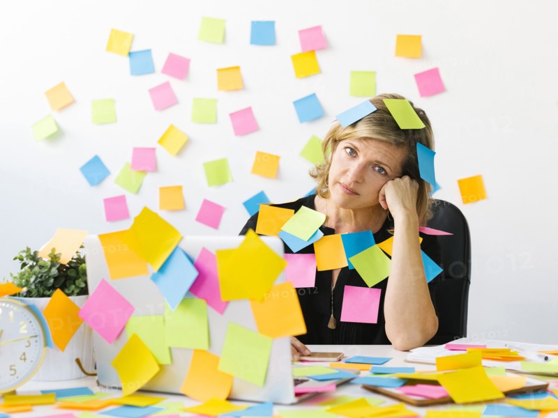 Portrait of Mature woman at office covered with adhesive notes