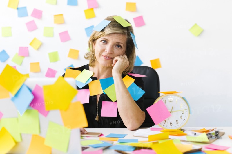 Portrait of Mature woman at office covered with adhesive notes