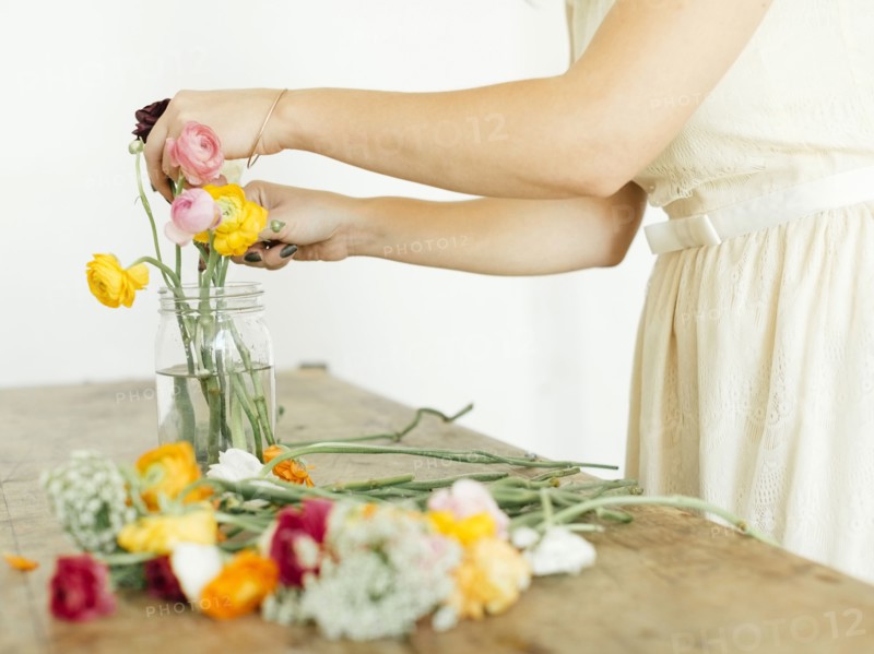 Woman putting flowers into jar