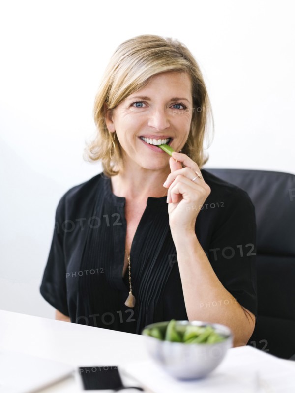 Woman eating green peas