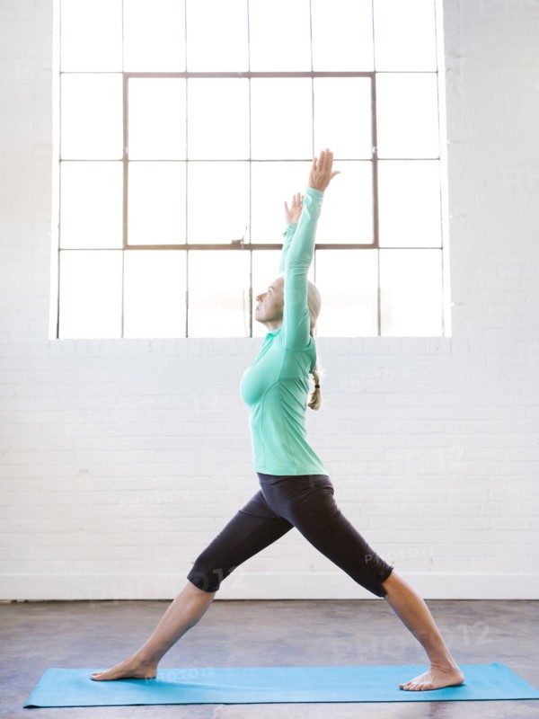 Senior woman practicing yoga on mat