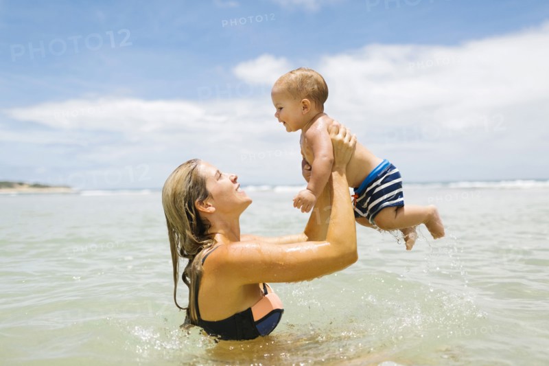 Mother playing with son (12-17 months) in sea