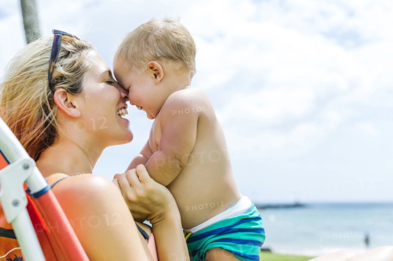 Woman sitting on deck chair with little son (18-23 months)