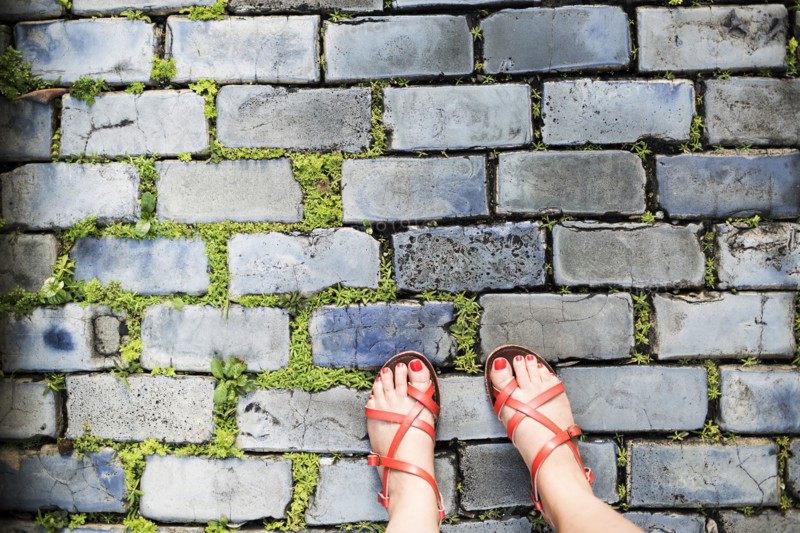 Woman in sandals standing on street