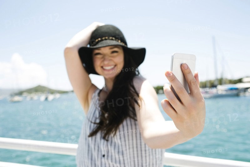 USA, Virgin Islands, Saint Thomas, Woman doing selfie with bay in background
