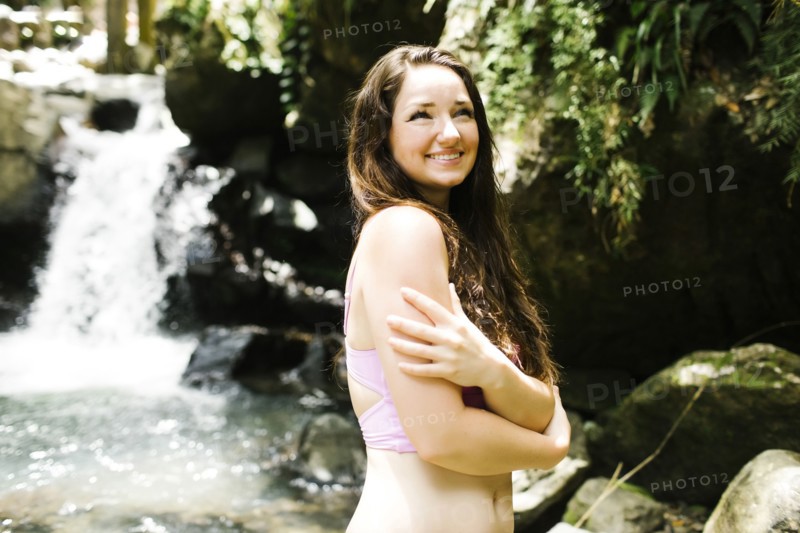 Caribbean Islands, Saint Lucia, Women by waterfall hugging self