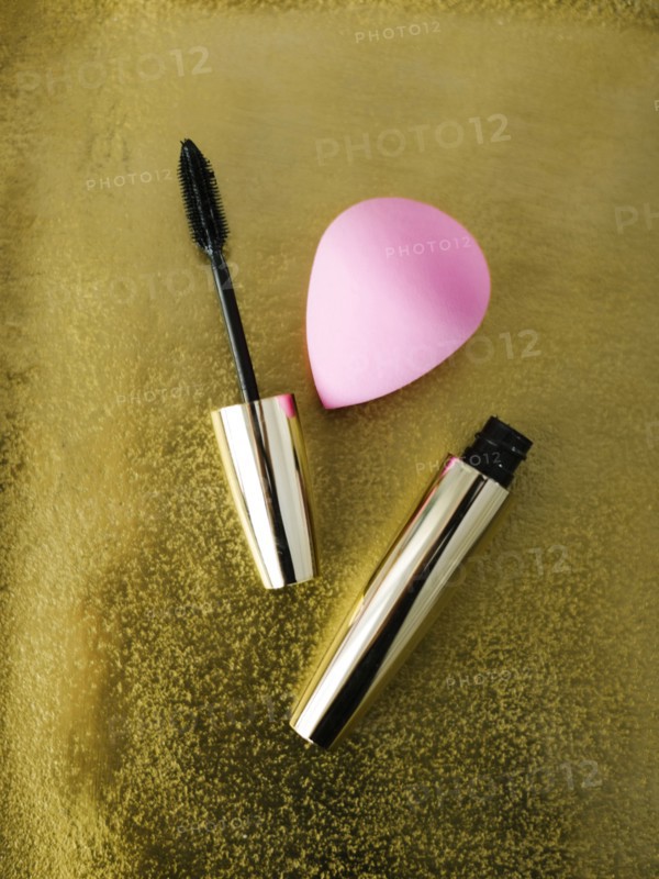 Mascara and small sponge on shiny background