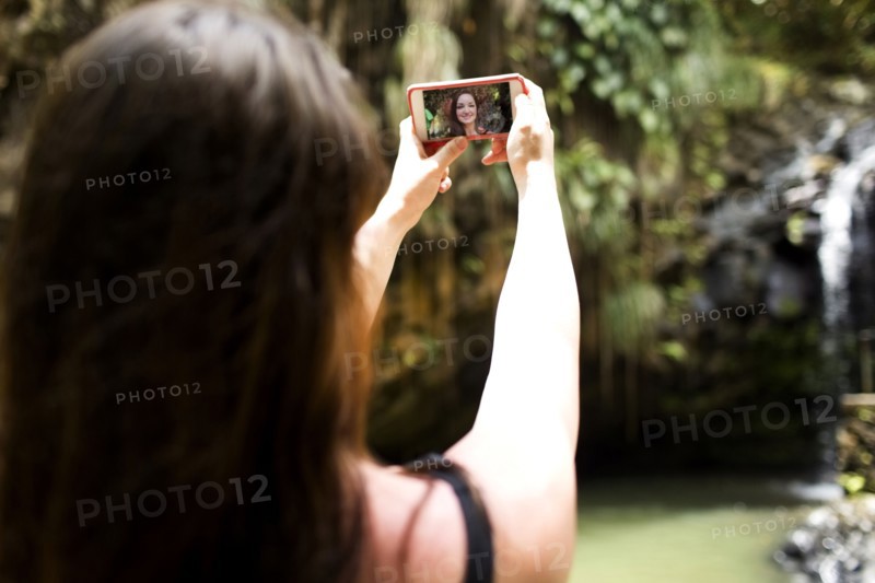 Saint Lucia, Woman taking selfie in front of waterfalls