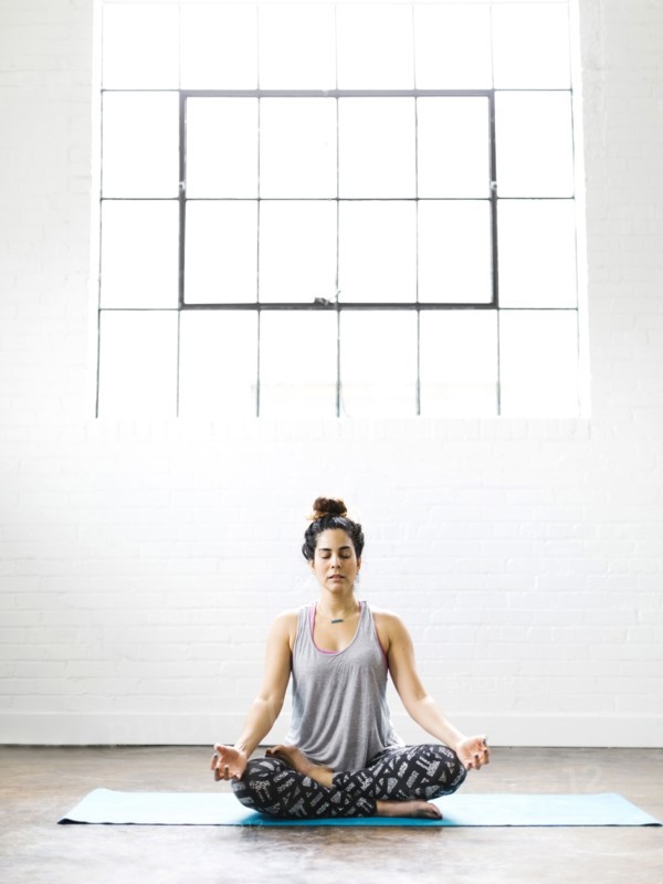 Woman meditating on exercise mat