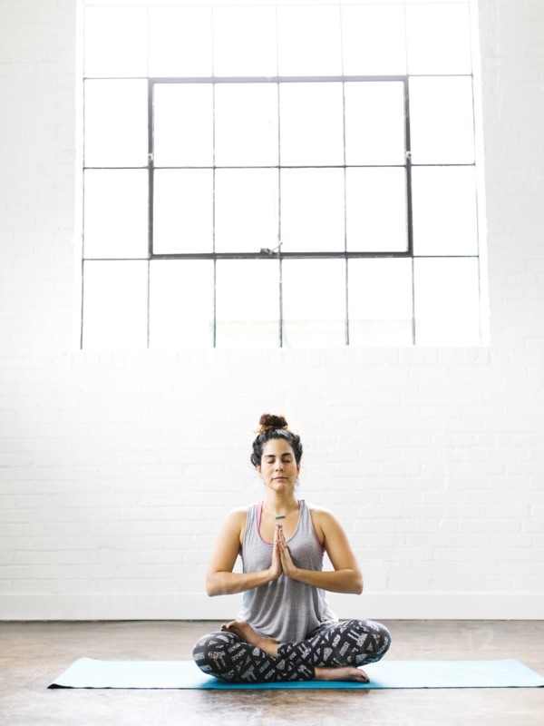 Woman meditating on exercise mat