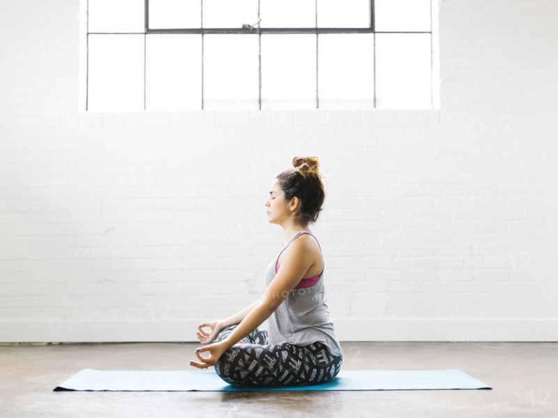 Woman meditating on exercise mat