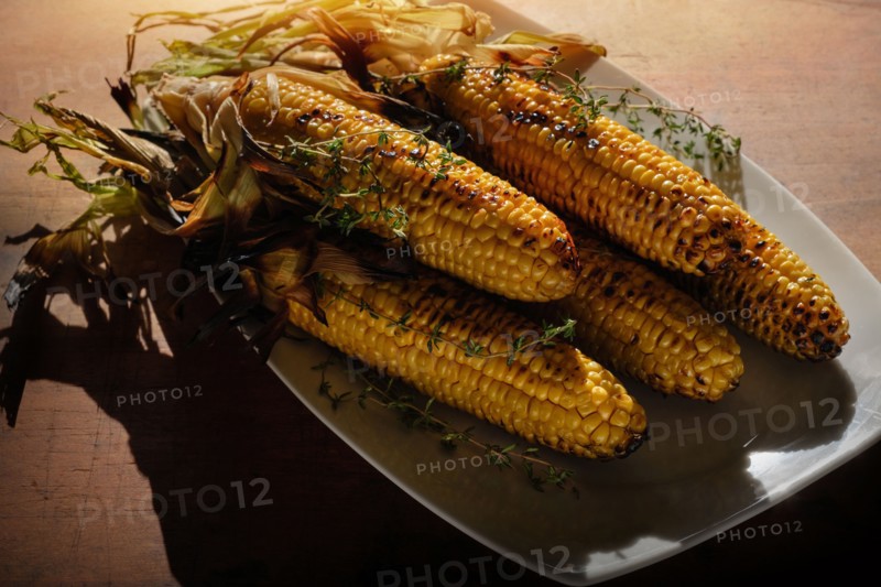 Grilled corn on cob with thyme on plate