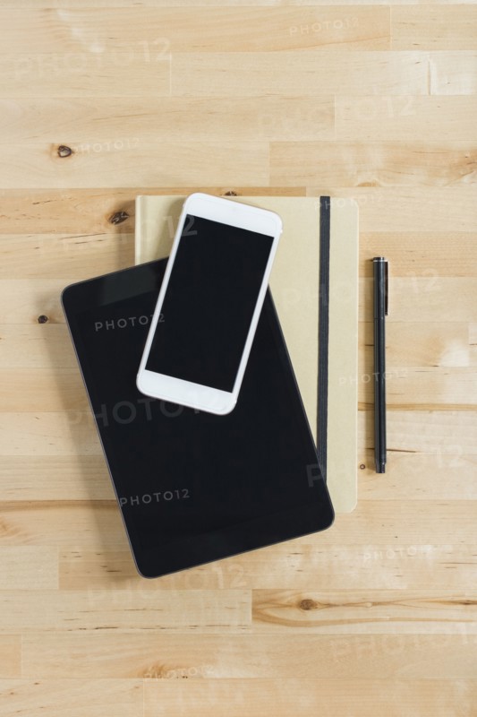 Directly above view of smart phone and personal organizers on wooden desk