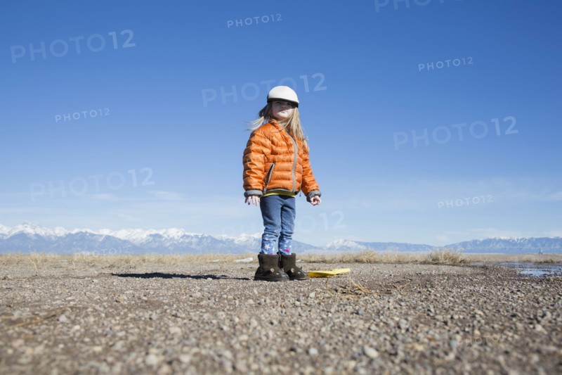 USA, Colorado, Little girl (4-5) dressed in orange padded jacket and flat cap