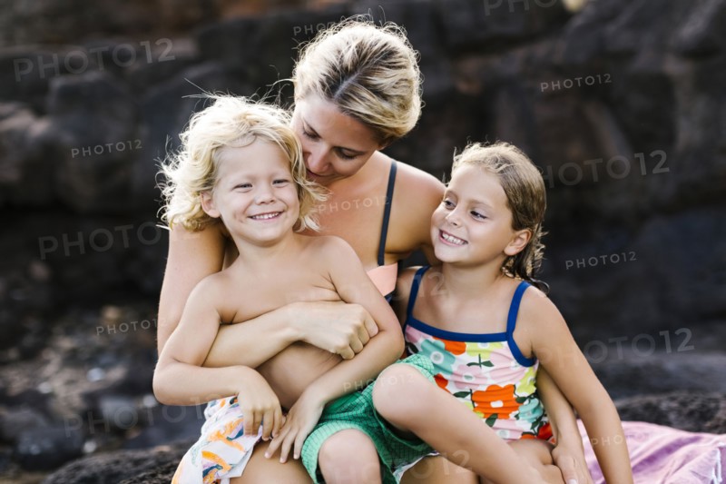 Mother embracing kids (4-5, 6-7)