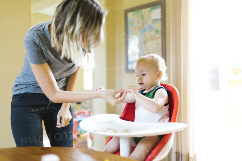 Mother feeding son (12-17 months) with breakfast cereals