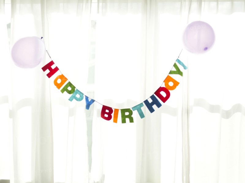 Birthday garland hanging in front of net curtain