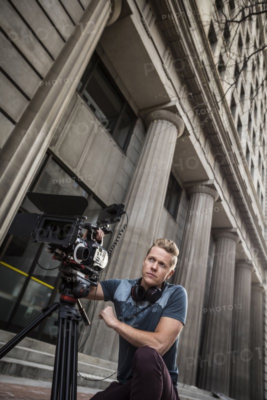 Serious camera operator looking away