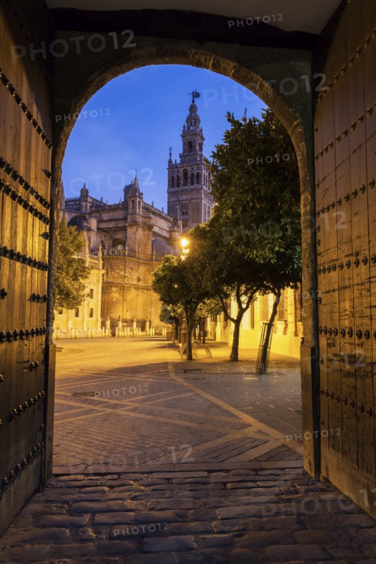 Spain, Andalusia, Seville, Arched corridor with Seville Cathedral (Cathedral of Saint Mary of the See) in background