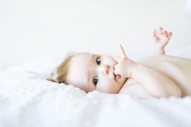 Portrait of baby girl (6-11 Months) with finger in mouth