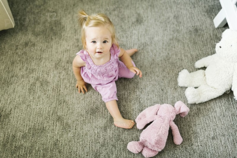 Portrait of baby girl (12-17 months) sitting on floor