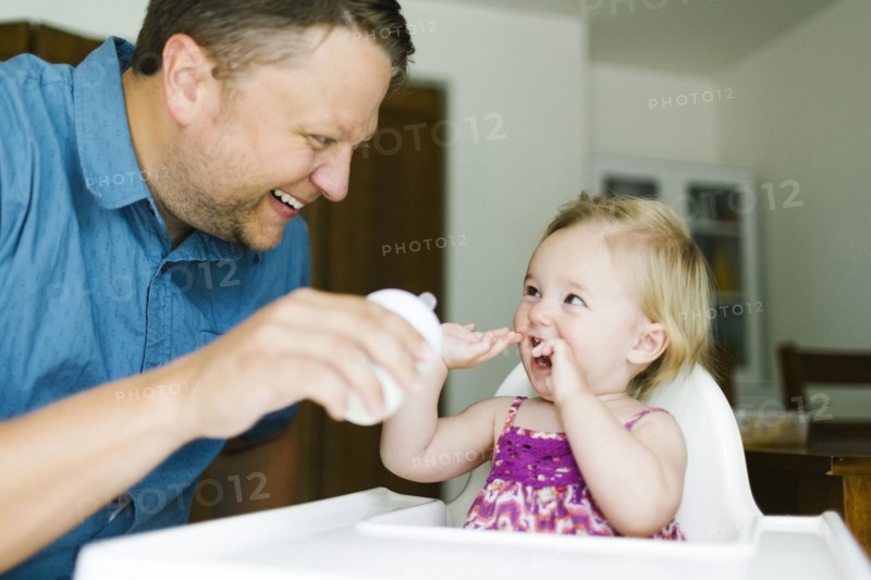 Father feeding baby girl (12-17 months)