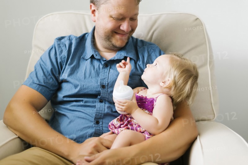 Father feeding baby girl (12-17 months)