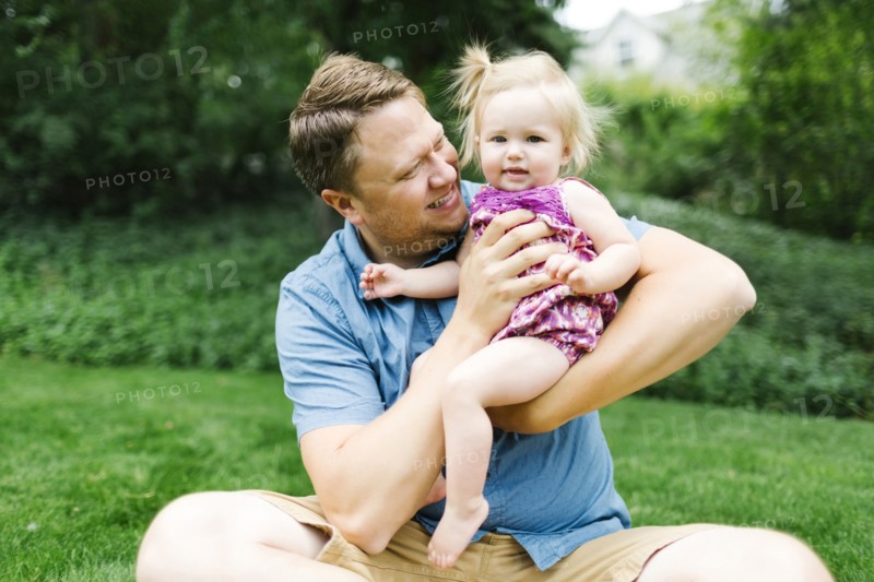 Father playing with baby girl (12-17 months) in backyard