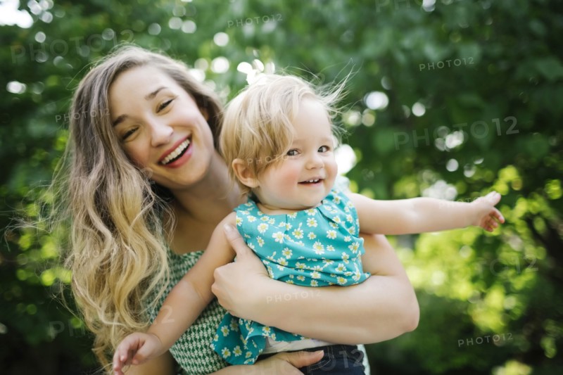 Portrait of mother carrying daughter (12-17 months)