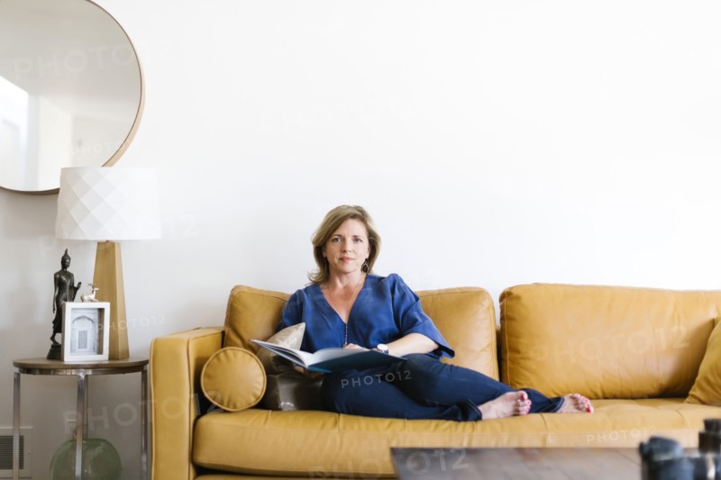 Woman sitting on sofa in living room