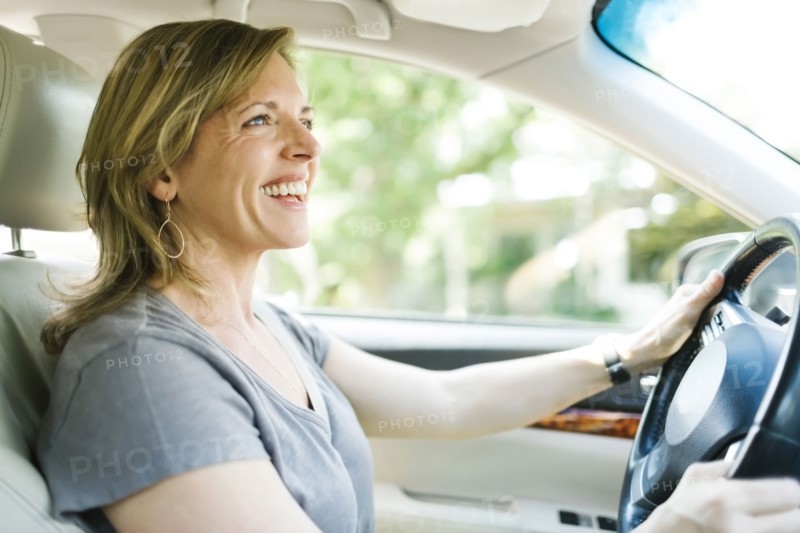 Smiling woman driving car