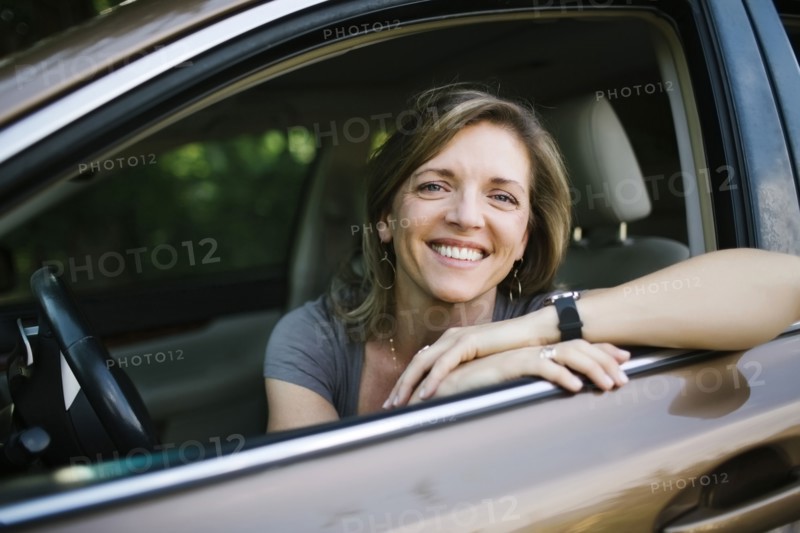 Portrait of smiling woman looking through car window