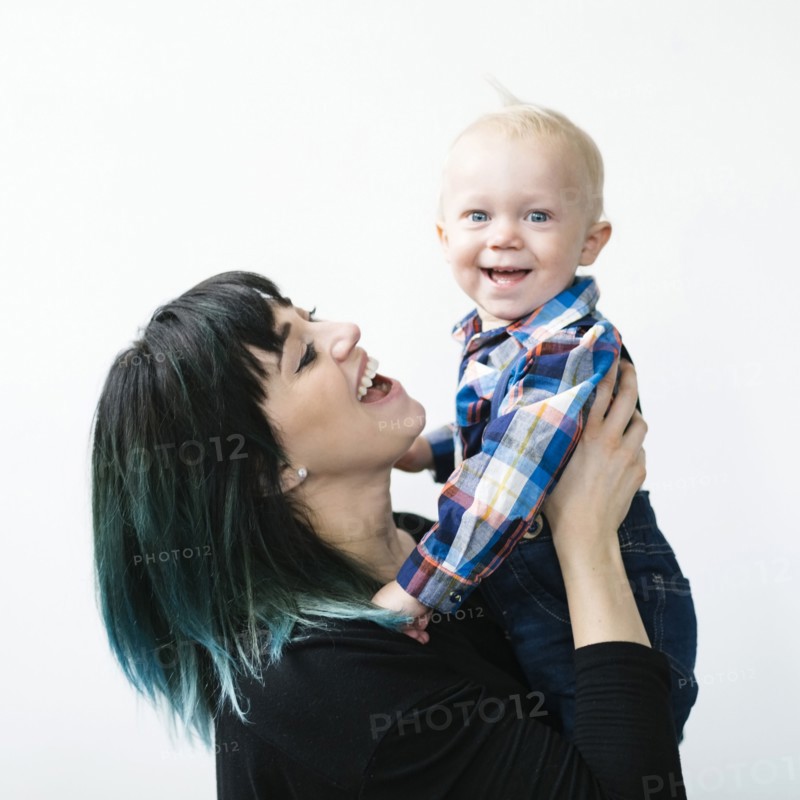 Portrait of mother holding son (12-17 months) against white background