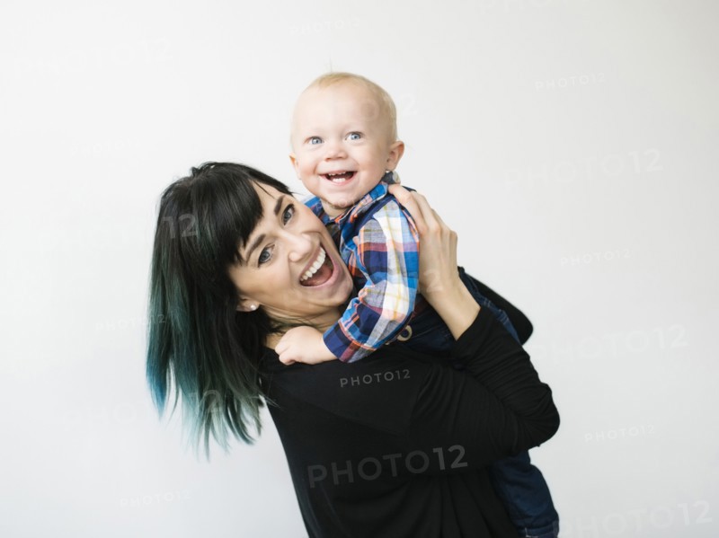 Portrait of mother holding son (12-17 months) against white background