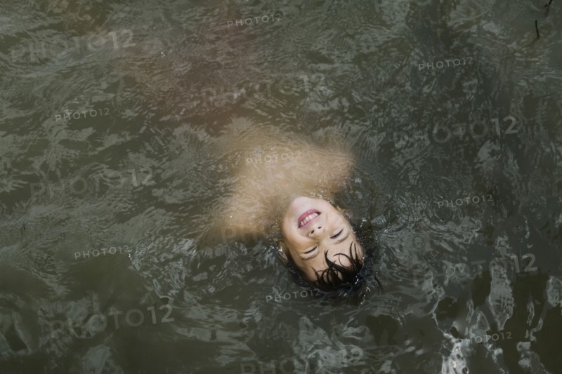 Boy (6-7) floating in lake