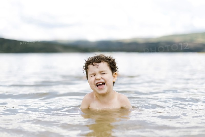 Smiling boy ( 4-5) swimming in lake