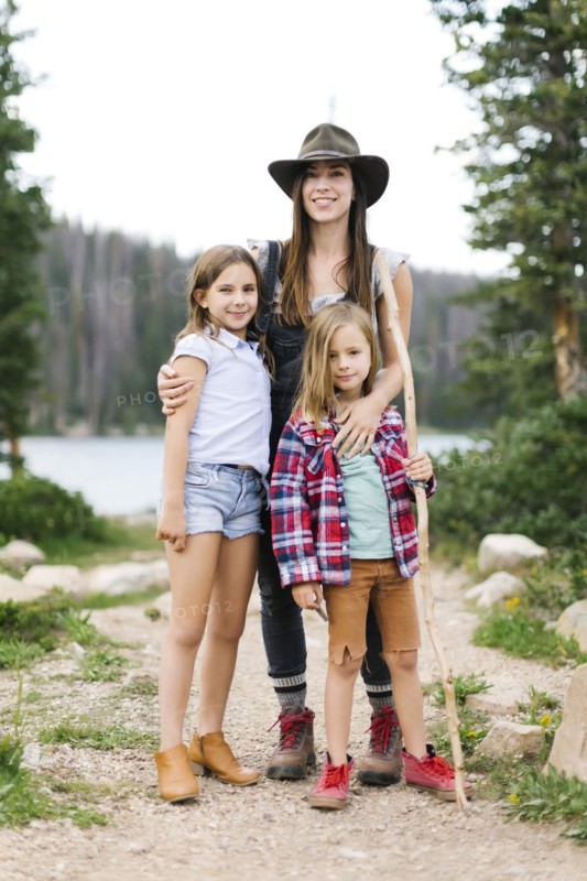 Outdoor portrait of mother with kids (6-7, 8-9) in forest