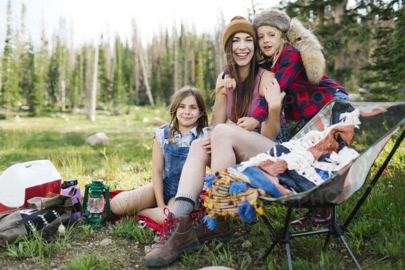 Mother with son (6-7) and daughter (8-9) camping in forest