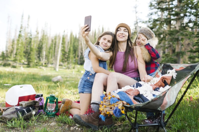 Mother with son (6-7) and daughter (8-9) camping in forest