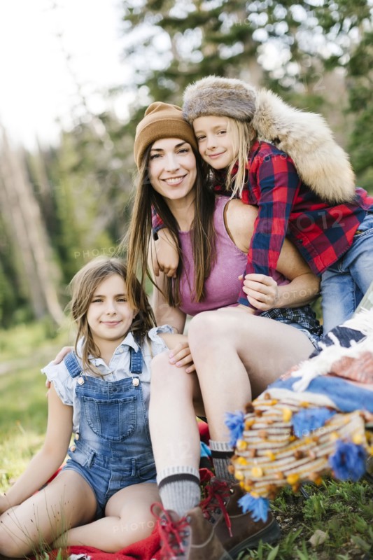 Mother with son (6-7) and daughter (8-9) camping in forest