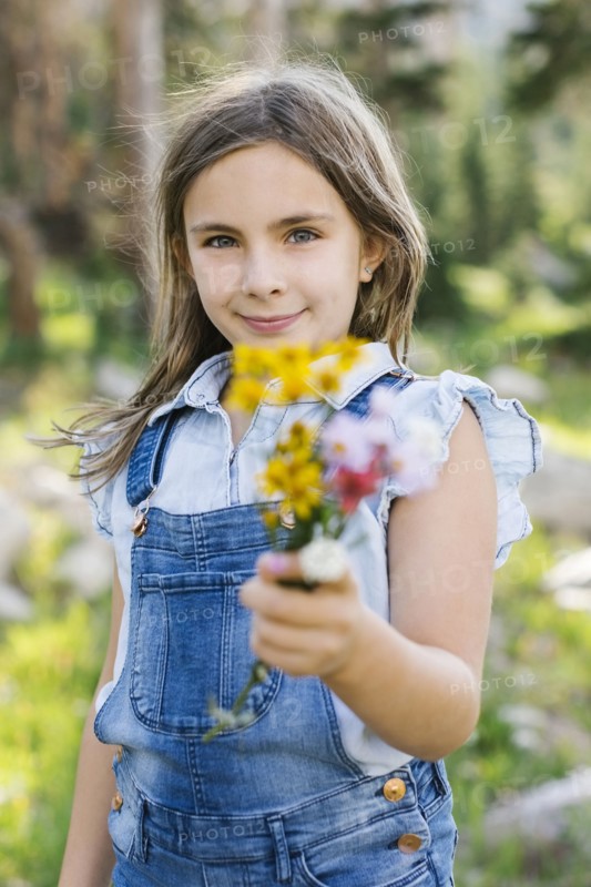 Portrait of girl (8-9) holding wildflowers